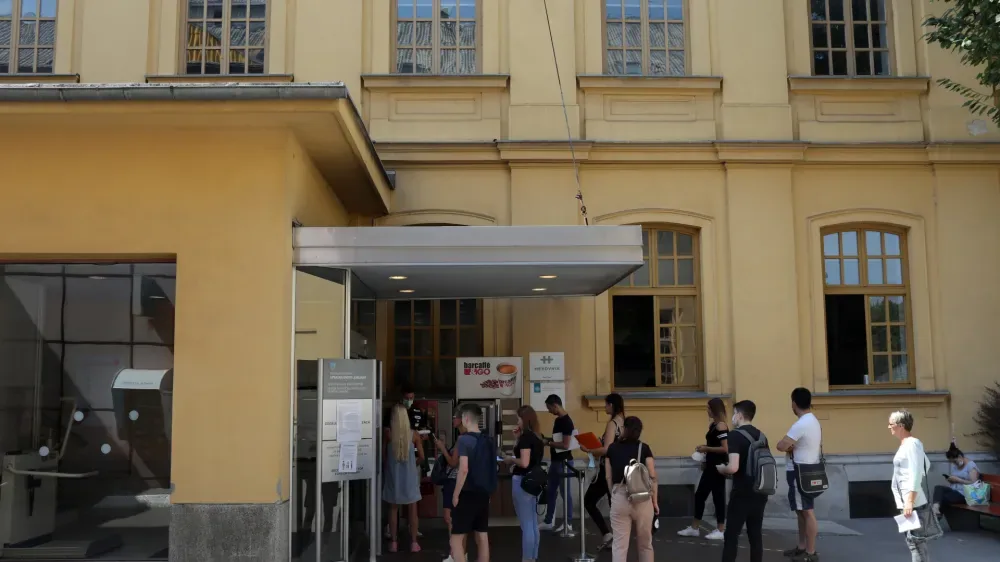 Študenti čakajo v vrsti pred upravno enoto v Ljubljani.